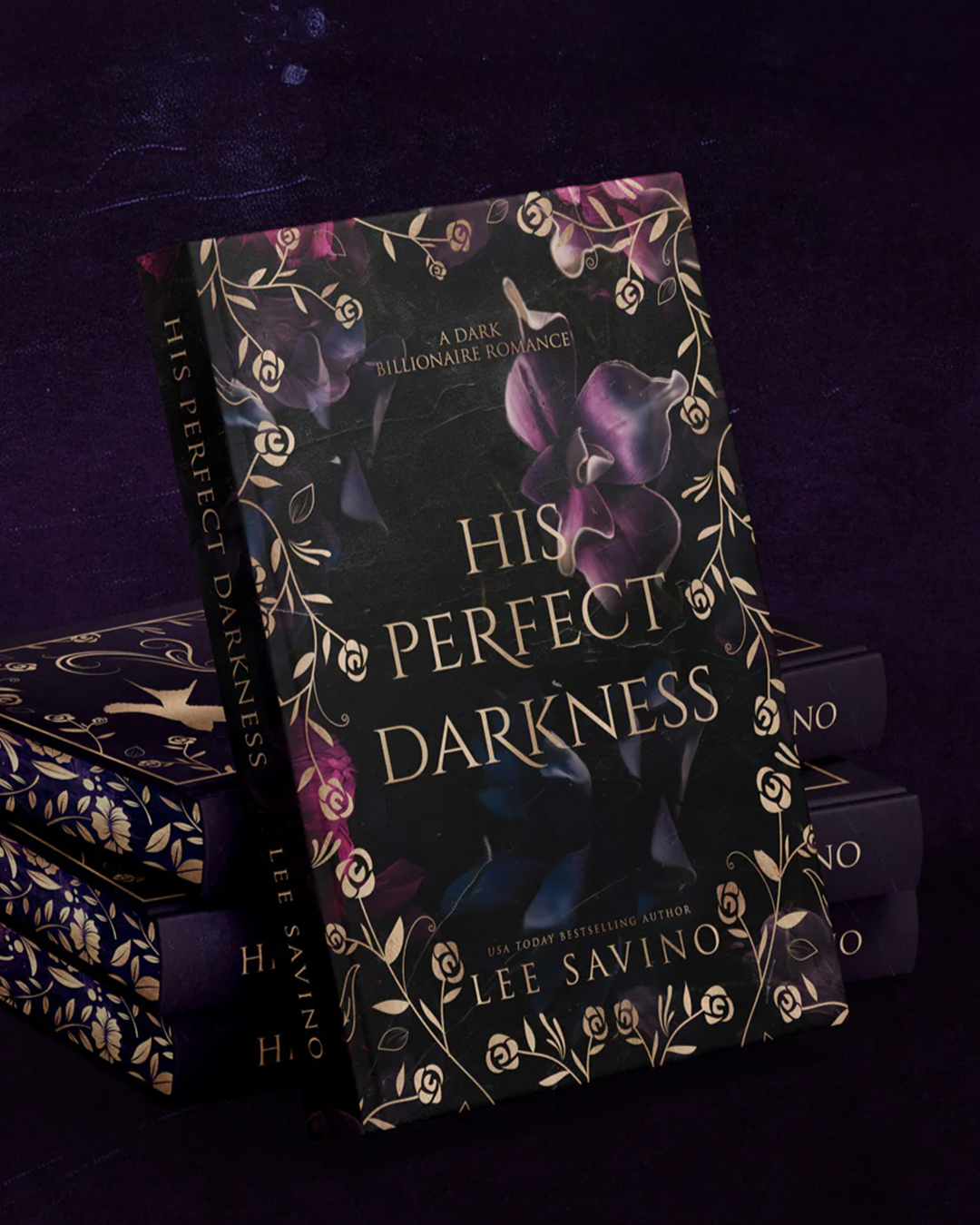 Hardcover novel standing upright against a stack of copies on a deep purple backdrop